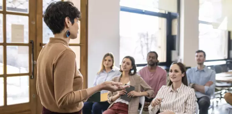 A woman giving a  presentation to a small group of people