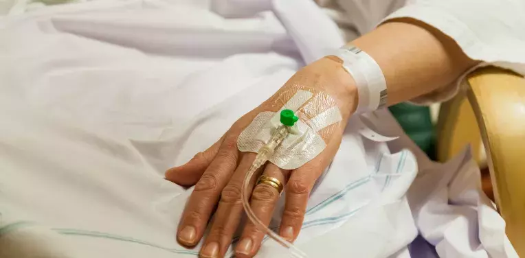 Female patient in hospital getting treatment by peripheral intravenous transfusion catheter